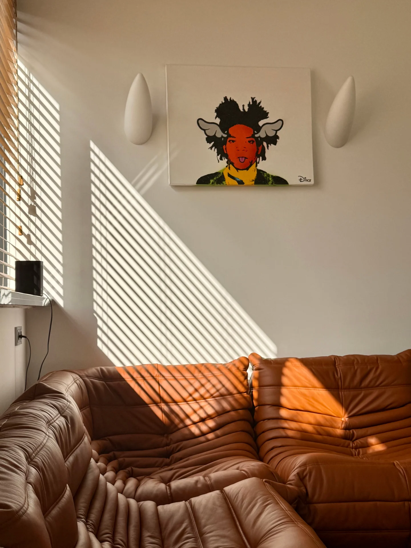 Basquiat-inspired canvas above tan leather Togo sofa
